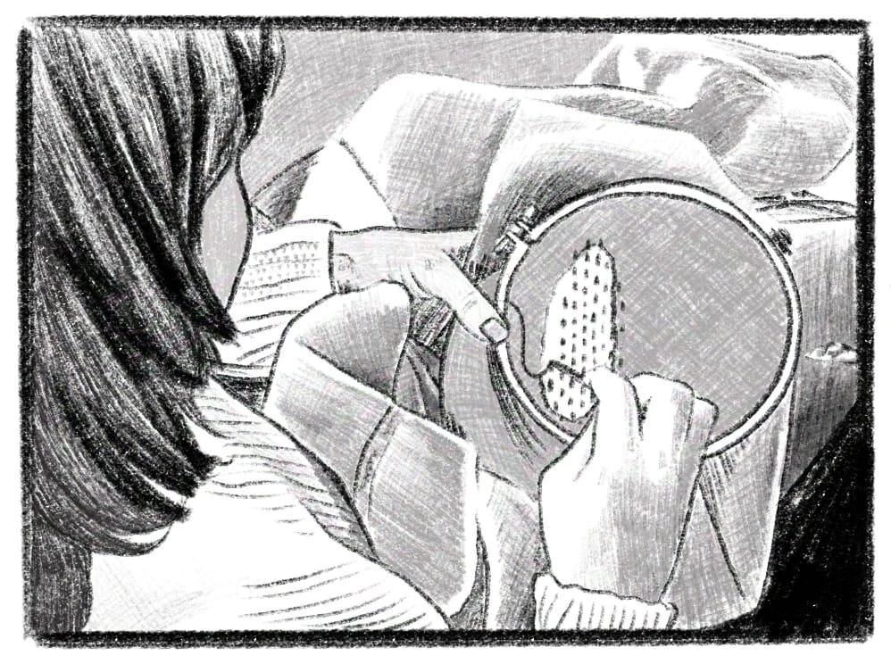 Person mending a hole in fabric from over the shoulder